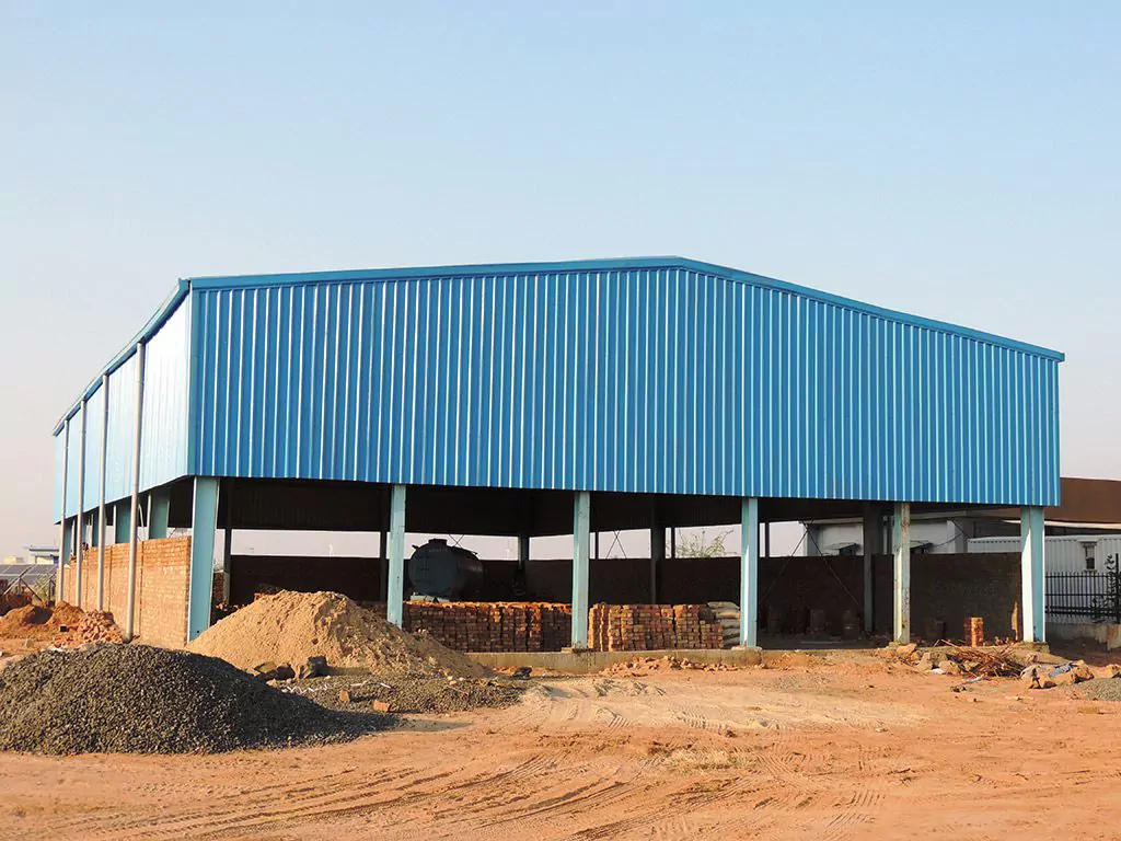 Completed pre-engineered building shed with blue metal cladding and brick infill walls