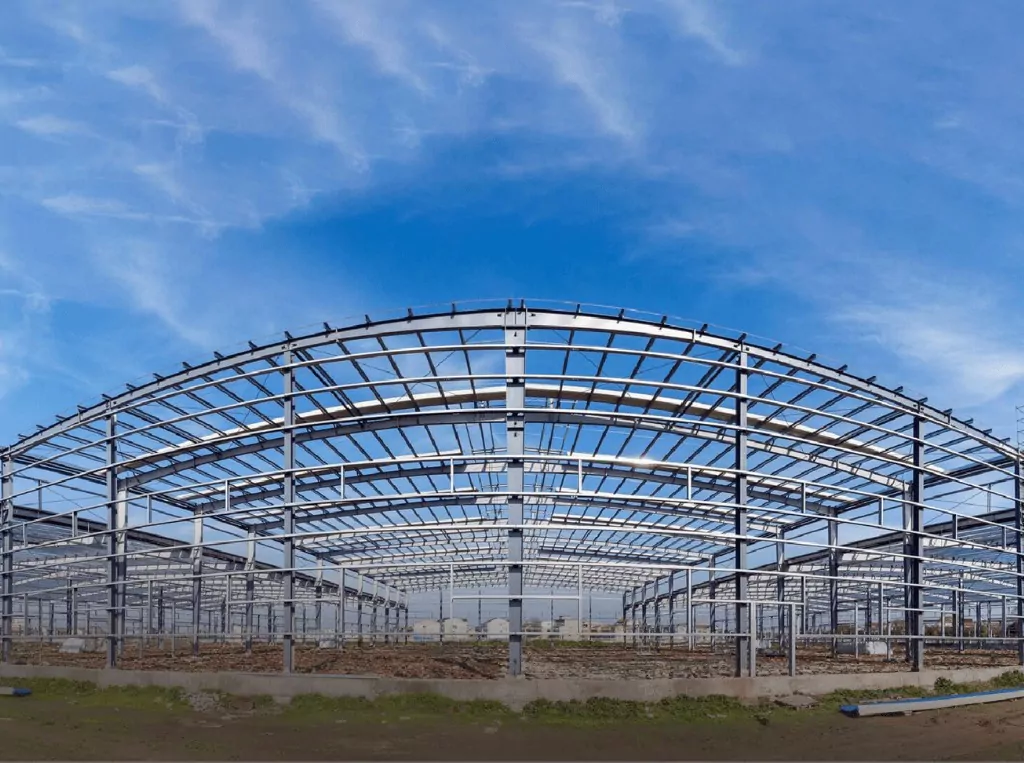 Wide-span arched roof pre-engineered building structure under erection, panoramic view